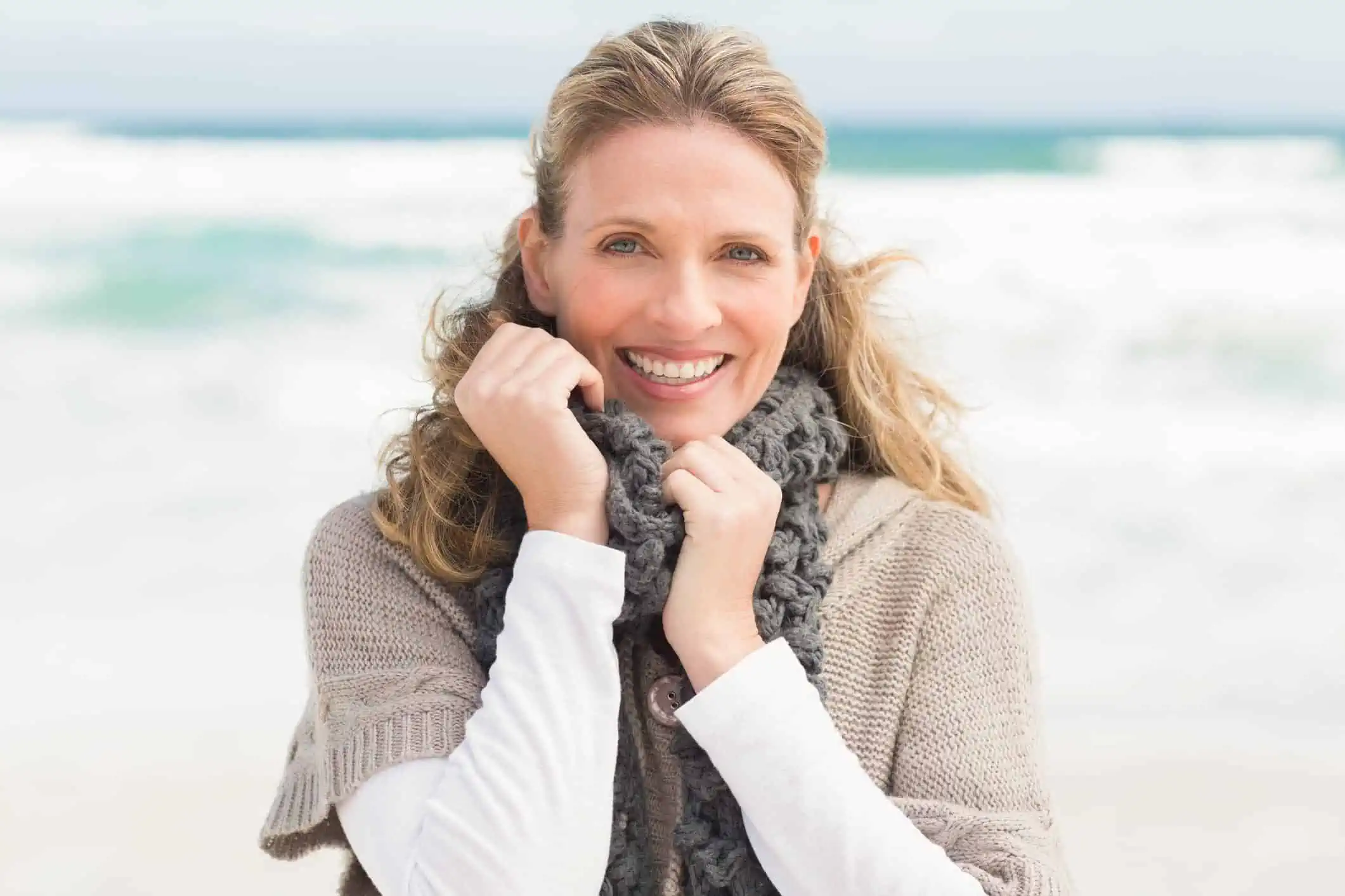 Woman in winter clothing on the beach