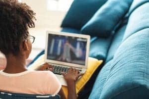 Young woman looking at laptop exposing her skin to blue light also known as HEV light