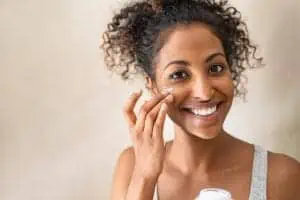 Woman applying moisturizer as part of her skin care routine