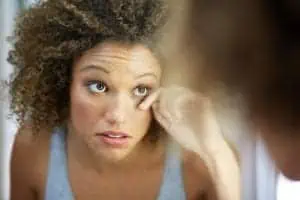 Black woman examining her eye