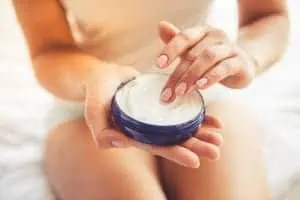 Woman applying lotion or cream