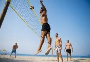 Young men playing beach volleyball.