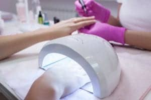 Hand in UV lamp during gel manicure