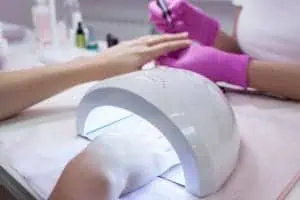 Hand in UV lamp during gel manicure
