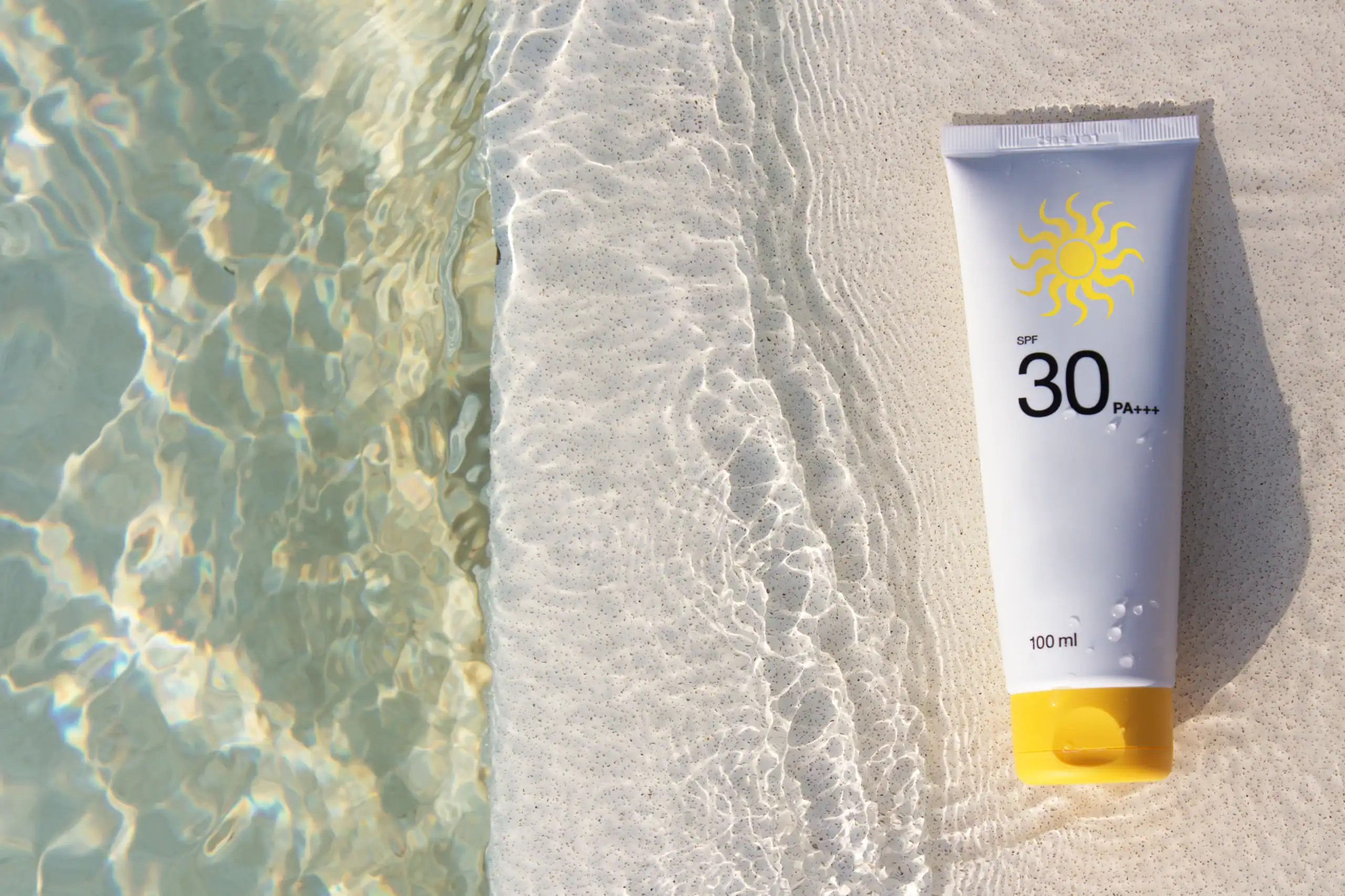 Tube of suncreen on the edge of a pool