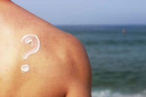 Man with sunscreen on his back in the shape of a question mark.