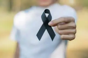 Woman showing black melanoma ribbon