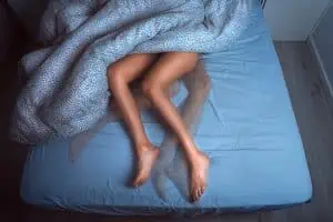 Woman in bed with restless leg syndrome