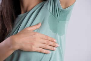 Woman with armpit sweat on t-shirt. Botox for sweating could help.