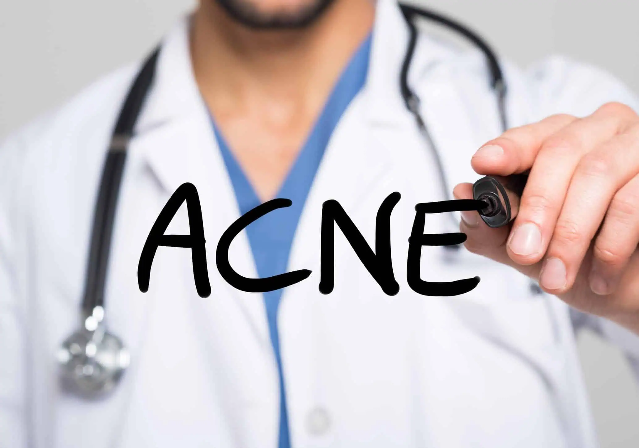 Doctor drawing the word acne on screen