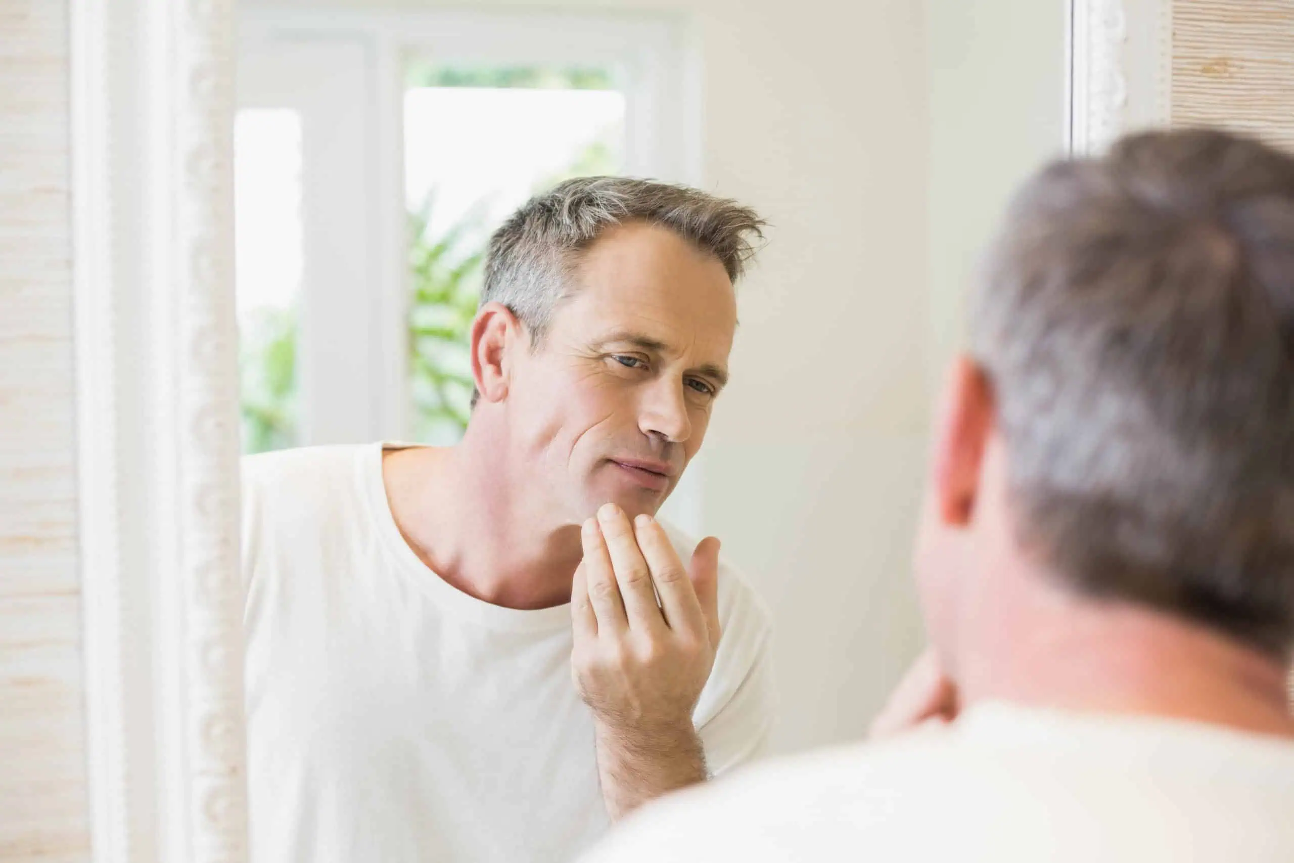 Man checking his lips in the mirror